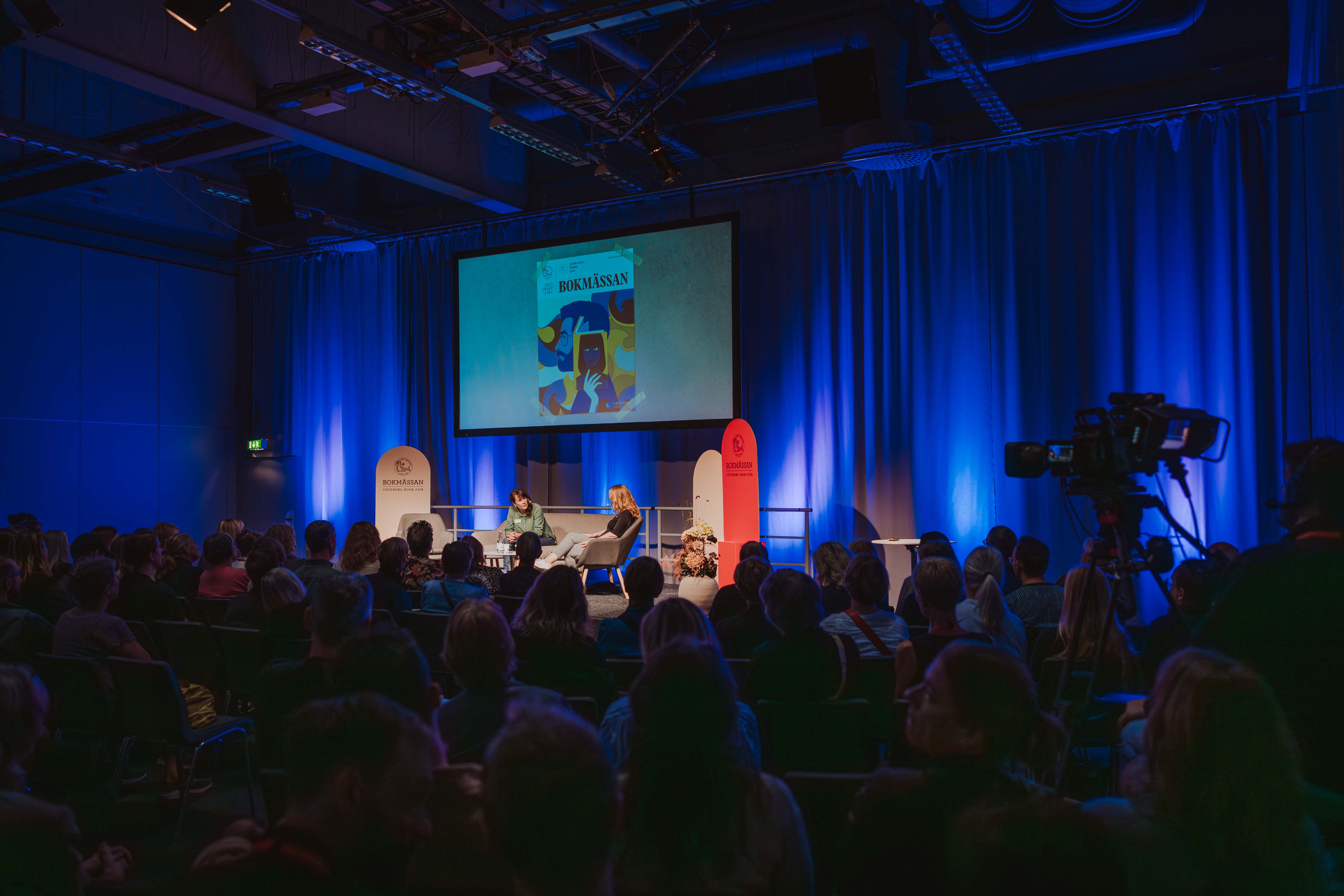 Scensamtal på Bokmässan med publik i förgrunden.