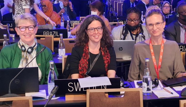 Tre kvinnor från Sveriges delegation till CONFINTEA-konferensen sitter bredvid varandra vid ett bord.
