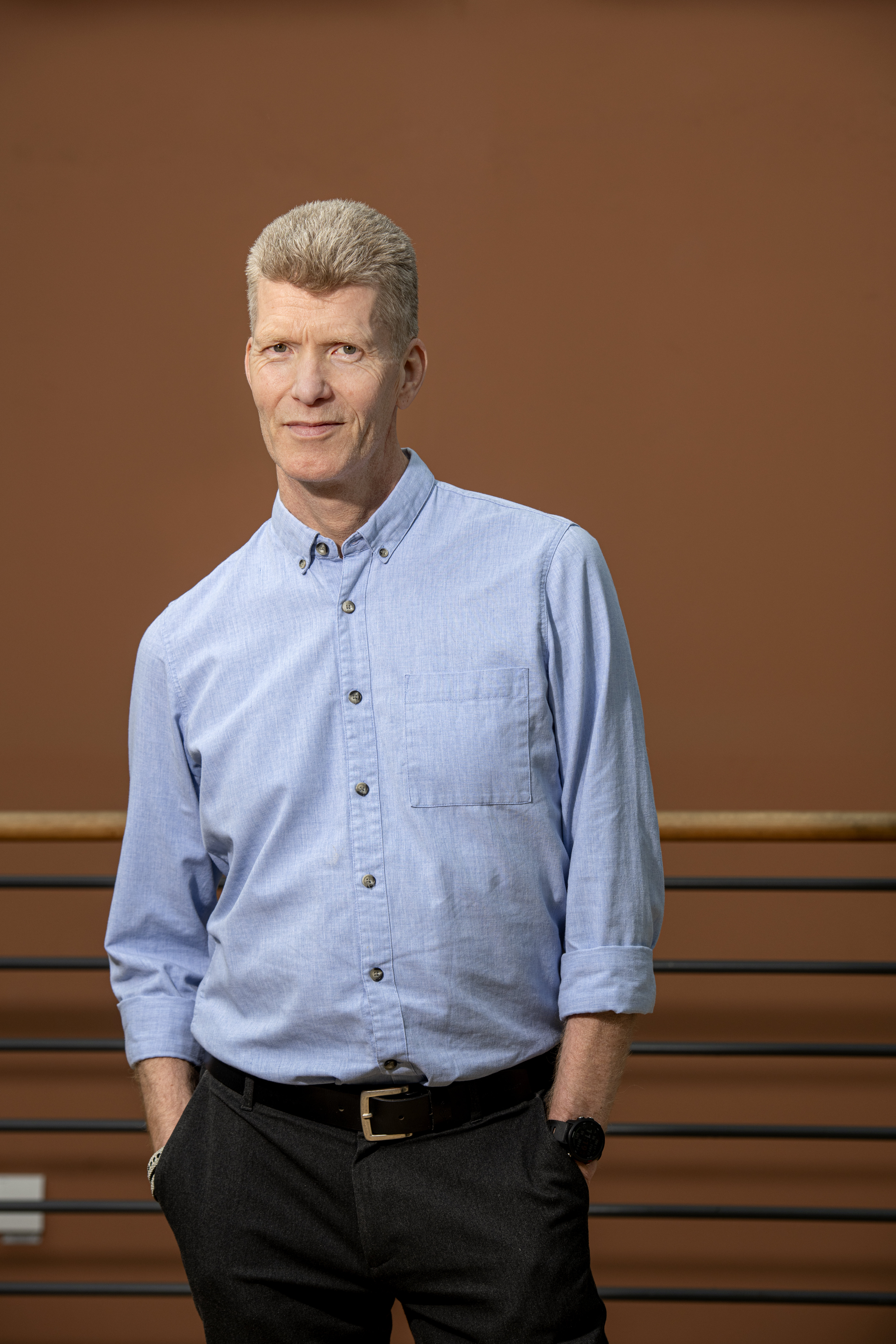 Jan Jonsson i ljusblå skjorta framför tegelröd vägg.