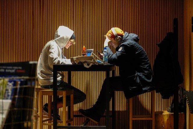 Två unga personer sitter och studerar vid ett bord. 