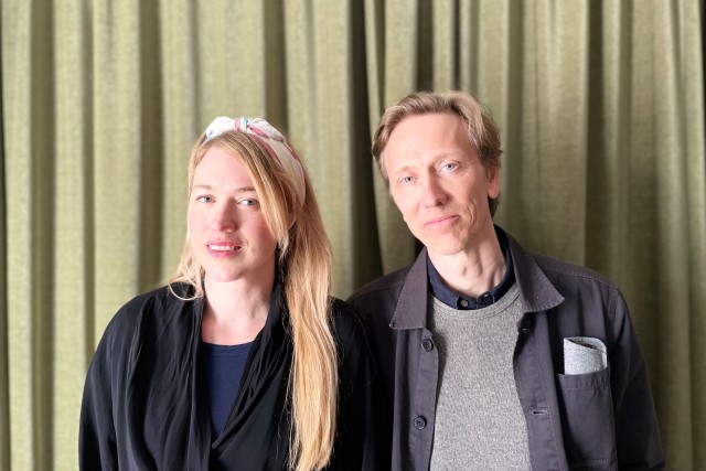 Felicia Hedström och Ola Bo Larsson, programledarna för Folkbildningspodden. De står framför ett grönt draperi och tittar in i kameran.