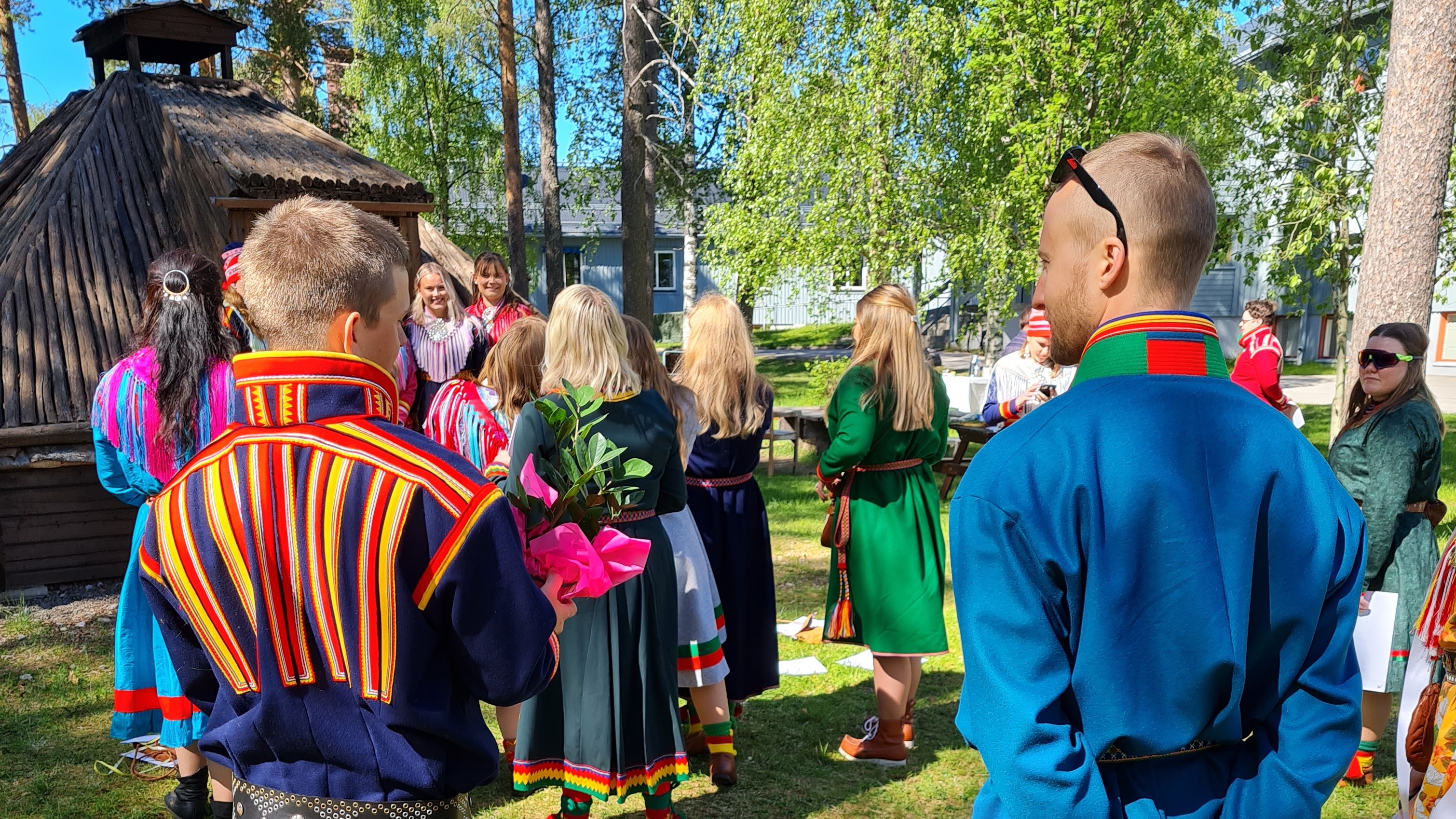 En grupp personer i traditionell samisk klädsel utomhus.